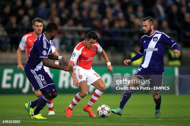 Anderlecht's Chancel Mbemba and Steven Defour battle for the ball with Arsenal's Alexis Sanchez