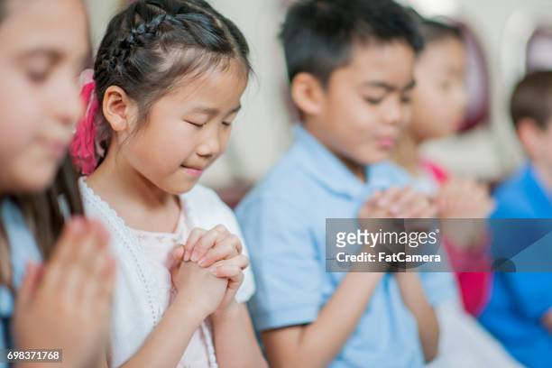praying at sunday school - child praying school stock pictures, royalty-free photos & images