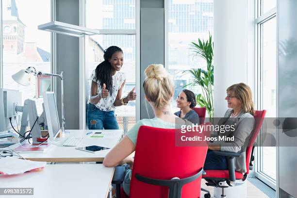 women working together - red office chair stock pictures, royalty-free photos & images