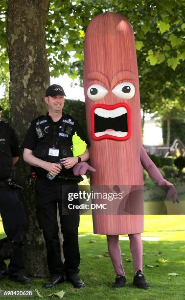 Policeman poses with man dressed in a sausage cotume at Royal Ascot 2017 at Ascot Racecourse on June 20, 2017 in Ascot, England.