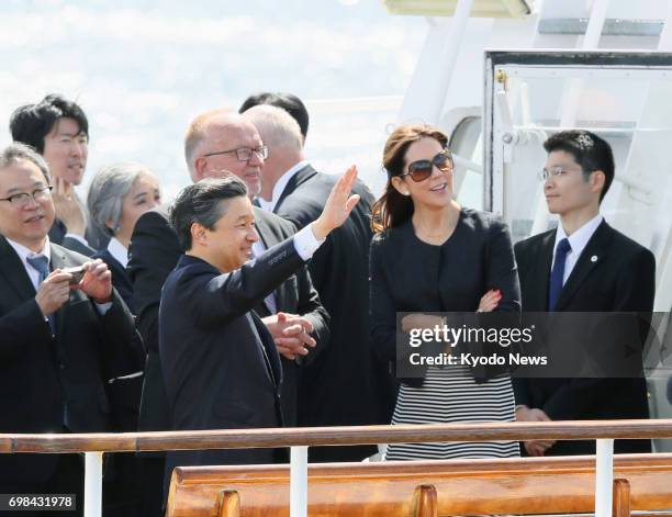 Japan's Crown Prince Naruhito waves on a boat, accompanied by Denmark's Crown Princess Mary , while cruising through Copenhagen harbor on June 20,...