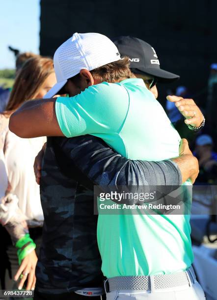 Brooks Koepka of the United States hugs coach Claude Harmon after winning the 2017 U.S. Open at Erin Hills on June 18, 2017 in Hartford, Wisconsin.