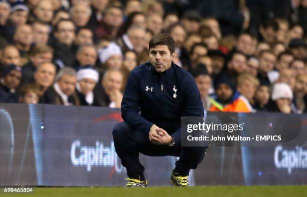 Tottenham Hotspur manager Mauricio Pochettino crouches on the touchline