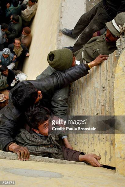 Thousands of Afghans fight to get into the Olympic stadium February 15, 2002 to see the "Game of Unity" soccer match between Kabul United and the...