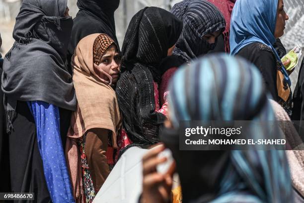 Displaced Iraqis wait to fill jerricans with water at al-Khazir camp for the internally displaced, located between Arbil and Mosul, on June 20 during...