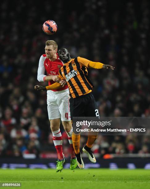 Arsenal's Per Mertesacker and Hull City's Yannick Sagbo battle for the ball