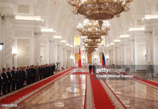 Russian President Vladimir Putin greets Kyrgyz President Almazbek Atambayev during their talks at the Grand Kremlin Palace in Moscow, Russia, June...