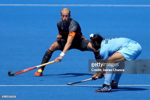 Billy Bakker of the Netherlands attempts to block a pass from Satbir Singh of India during the Pool B match between India and the Netherlands on day...