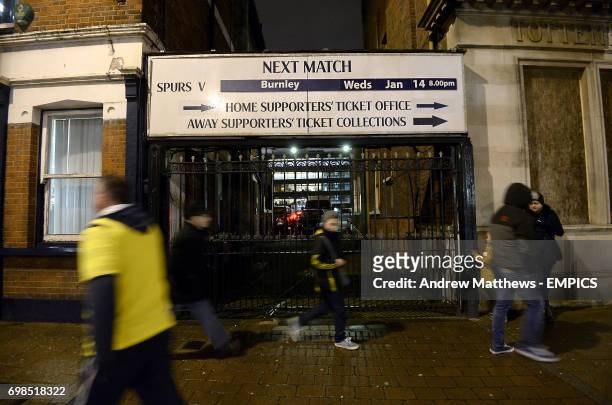 Supporters make their way past a sign outside White Hart lane advertising the FA Cup third round replay tie against Burnley