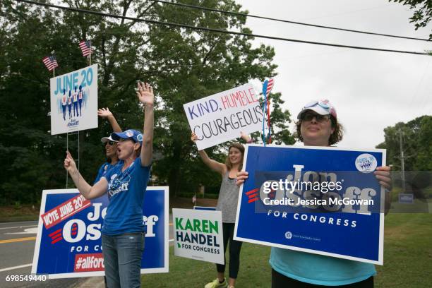 Jan Yanes and Tammy Harper of Roswell, supporters of Democratic candidate Jon Ossoff, wave at cars passing by St. Mary's Orthodox Church of Atlanta...