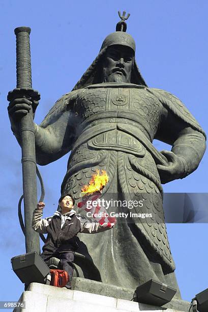 South Korean student burns a American flag at the base of the statue of the South Korean Navy General Yi Soon-shin February 15, 2002 near the U.S....