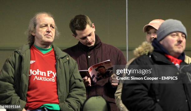 Kevin Richmond reads a copy of the program prior to kick off