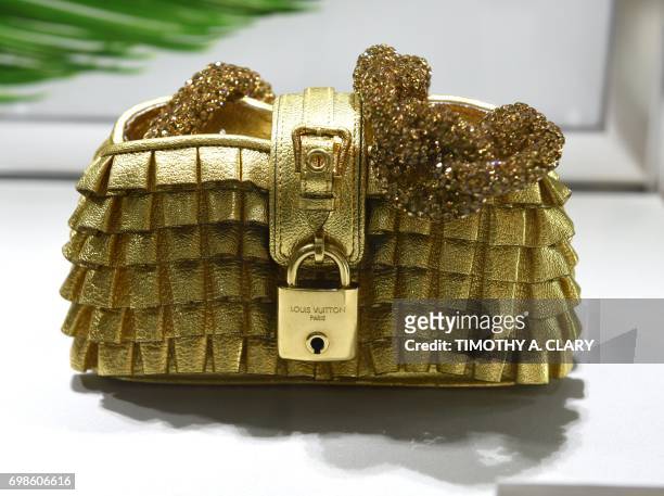 Louis Vuitton 2004 runway limited edition Les Extraordinaires gold leather & crystal Pochette Accessories Volants bag is displayed at Christie's in...