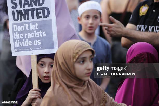 Children attend a vigil outside Finsbury Park Mosque in north London on June 20 following a van attack on pedestrians nearby on June 19. Ten people...