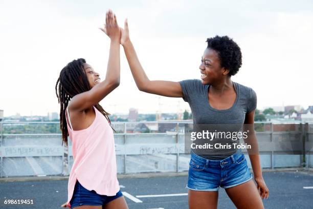 teenage girls giving each other high five - 13 year old girls in shorts stock pictures, royalty-free photos & images