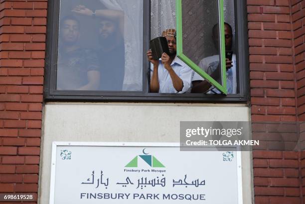 People watch a vigil from a window of the Finsbury Park Mosque in north London on June 20 following a van attack on pedestrians nearby on June 19....