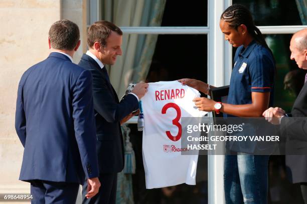 French President Emmanuel Macron received a jersey by Lyon's French captain Wendie Renard during a ceremony at the Elysee Palace in Paris on June 20,...