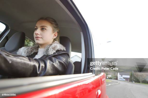 young woman sat in red car - paardenstaart haar naar achteren stockfoto's en -beelden