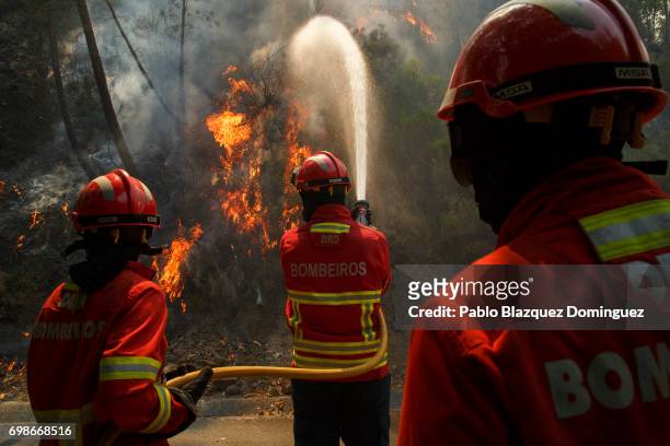 Firefighters battle a fire after a wildfire took dozens of lives on June 20, 2017 in Mega Fundeira village, near Picha, in Leiria district, Portugal....