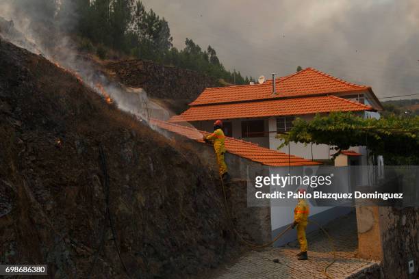 Firefighter extingish flames approaching Mega Fundeira village after a wildfire took dozens of lives on June 20, 2017 near Picha, in Leiria district,...