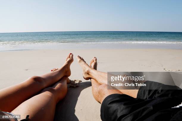 couple on beach with legs - beach holiday stock-fotos und bilder