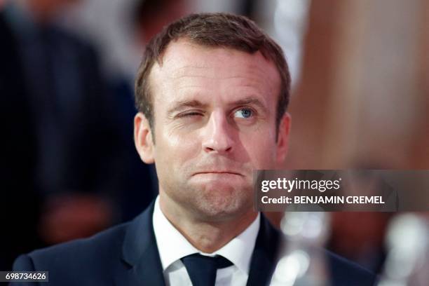 French President Emmanuel Macron grimaces as he attends a dinner organised by the French Council of the Muslim Faith to break the fast of Ramadan, in...