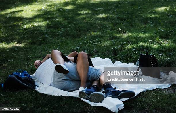Couple rest in Manhattan's Central Park on a hot afternoon on June 20, 2017 in New York City. Summer will officially begin tomorrow afternoon.