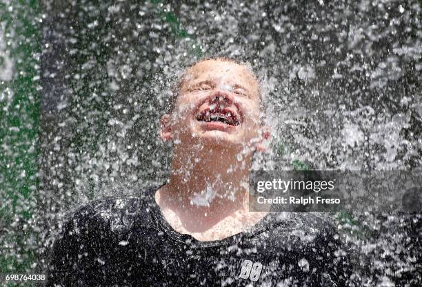 Young boy finds some relief from the heat under a cascading waterfall feature at the Wet-N-Wild Water Park on June 20, 2017 in Phoenix, Arizona....