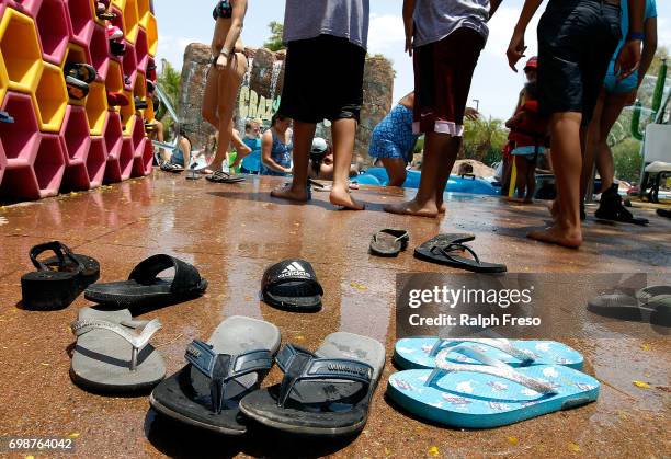 Flip flop sandals are left behind as visitors make their way into the water for relief from the heat at the Wet-N-Wild Water Park on June 20, 2017 in...