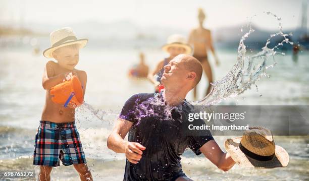 family playing in sea - bucket stock pictures, royalty-free photos & images