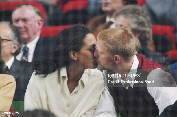 German tennis player Boris Becker kisses his future wife Barbara Feltus as they watch play at the 1993 Grand Slam Cup tennis tournament in Munich,...