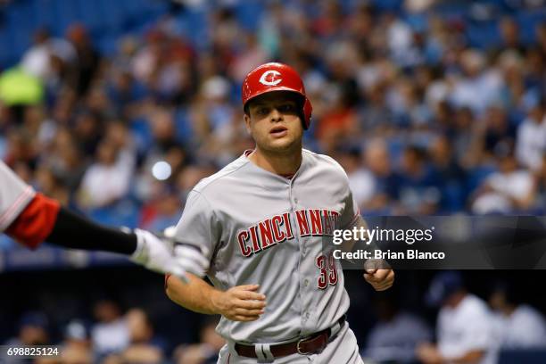 Devin Mesoraco of the Cincinnati Reds crosses home plate and heads to celebrate with teammate Billy Hamilton after scoring off of an RBI single by...