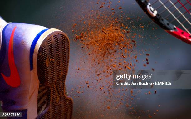 Clay breaks off the sole of the tennis shoe of Roger Federer as he serves during his Second round men's singles match against Marcel Granollers on...