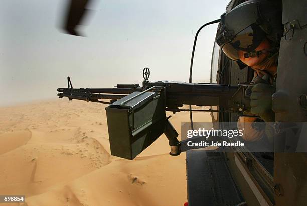 Army 101st Airborne Sgt. Jason Deer from Franklinville, New York flies in a Blackhawk helicopter as he mans his M-60 Delta machine gun February 16,...
