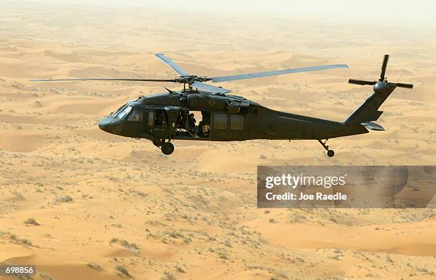 Blackhawk helicopter from the 101st Airborne flies over the desert sands February 16, 2002 during a reconnasance mission in Kandahar, Afghanistan....