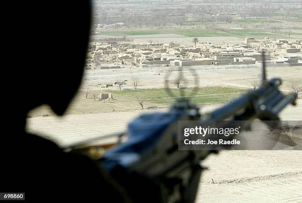 Army 101st Airborne SPC Robert Watson from Slocum, Texas flies in a Blackhawk helicopter as he mans his M-60 Delta machine gun February 16, 2002...