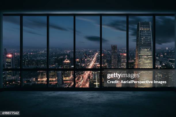 window view of illuminated urban skyline - skyscraper window stock pictures, royalty-free photos & images