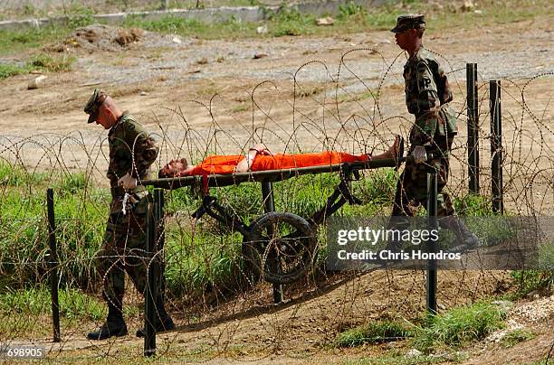 Marines transport a detainee on a gurney at Camp X-Ray February 6, 2002 in Guantanamo Bay, Cuba. Many of the 156 Al Qaeda or Taliban detainees are...