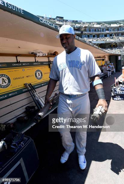 Chris Carter of the New York Yankees walks into the dugout to place his bats in the rack prior to the start of the game against the Oakland Athletics...