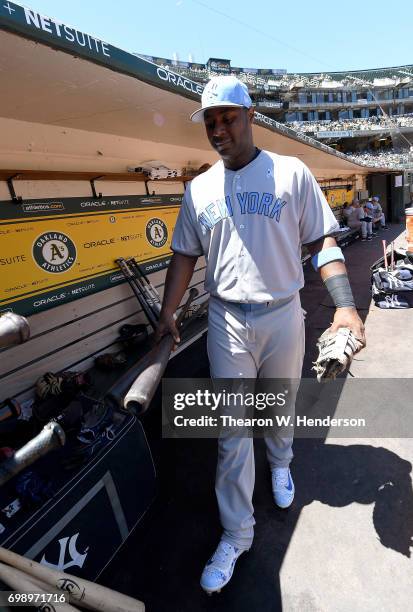 Chris Carter of the New York Yankees walks into the dugout to place his bats in the rack prior to the start of the game against the Oakland Athletics...