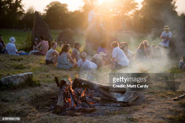People gather to watch the sun set at the Stone Circle ahead of the gates opening to the public amid heightened security this year at the Glastonbury...