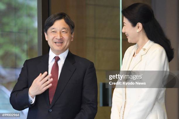 Japanese Crown Prince Naruhito and his wife Crown Princess Masako are seen at the entrance of their residence in Tokyo on June 21 after the crown...