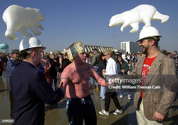 An unidentified man congratulates Keith Powers and Chris Schaub of West Chester, PA after they swam in the Atlantic Ocean during the 8th Annual Polar...