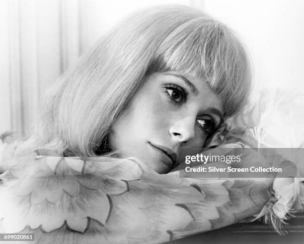 French actress Catherine Deneuve wearing a floral patterned blouse, circa 1970.