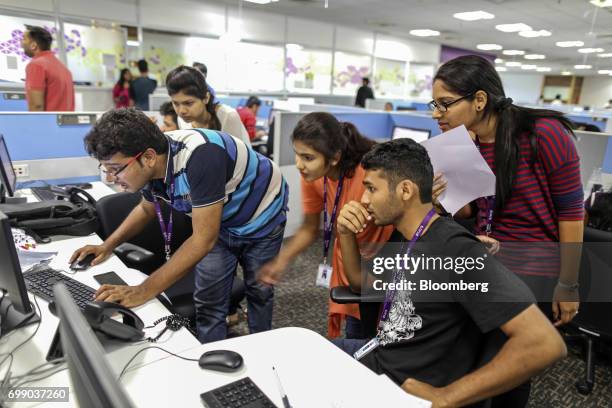 Employees gather at a computer in the Think and Learn Pvt. Office in Bengaluru, India, on Wednesday, April 5, 2017. Online learning is exploding in...