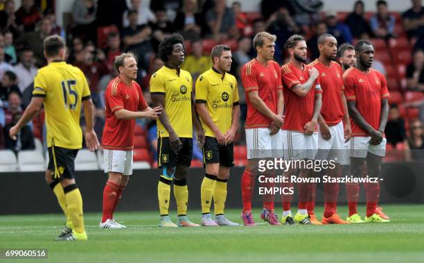 Nottingham Forest and Aston Villa players form a defensive wall against a free kick
