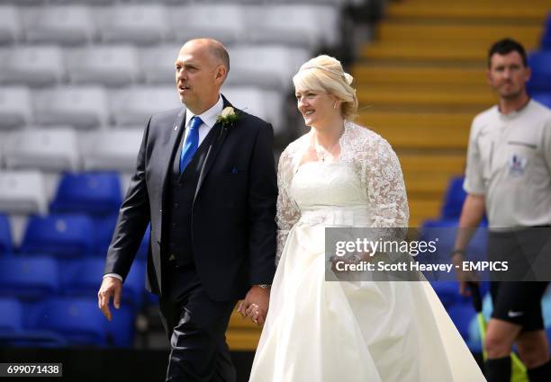 Newlywed couple lead the teams out onto the field of play before the game