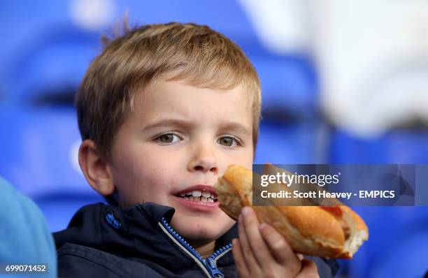 Young Birmingham City fan enjoys a bite to eat in the stands