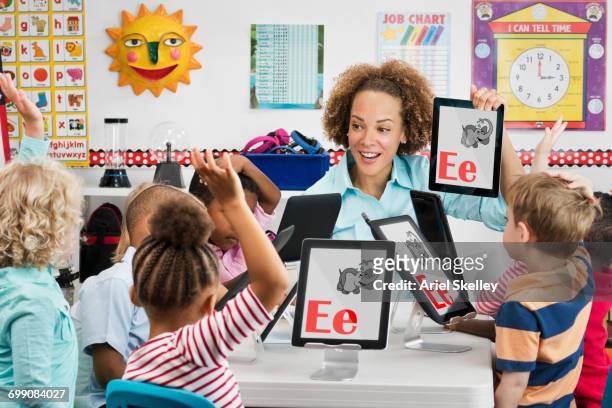 teacher and students learning alphabet with digital tablets - 5 years stock pictures, royalty-free photos & images