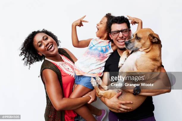 man and woman holding daughter and dog - small group of people stock-fotos und bilder